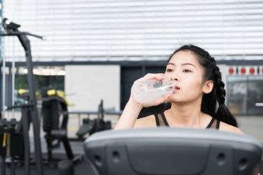 genç kadın fitness merkezinde içme suyu. kadın atlet ücreti