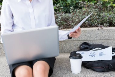 işkadını dizüstü bilgisayar ve oturan mali grafik ile