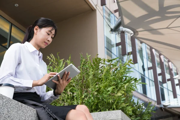 Επιχειρηματίας με ψηφιακό tablet που κάθεται έξω από το γραφείο κτίρ — Φωτογραφία Αρχείου