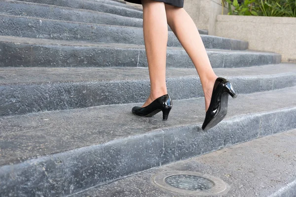 Füße und Bein der Geschäftsfrau tragen schwarze Schuhe mit hohen Absätzen — Stockfoto