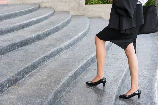 Pies y pierna de mujer de negocios con zapatos negros de tacón alto goin — Foto de Stock