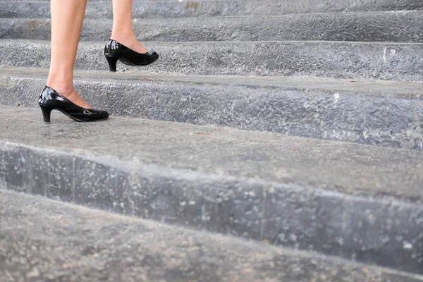 Pies y pierna de mujer de negocios con zapatos negros de tacón alto goin — Foto de Stock