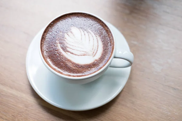 Heiße Schokolade mit Blatt-Latte-Art. Kakao-Getränk auf Holz — Stockfoto