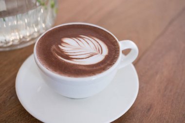 sıcak çikolata meşrubatının yaprak latte sanat ile. ahşap üzerine kakao içecek 