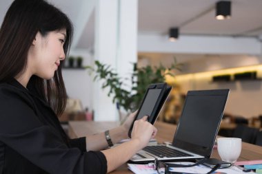 iş kadını işyerinde tablet kullanın. Tarih için çalışan genç kadın