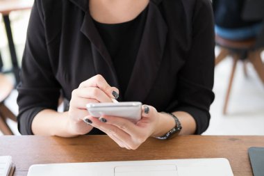 işyerinde iş kadını kullanım cep telefonu. genç kadın manifatura