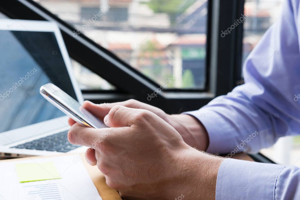 businessman use mobile phone at workplace. man texting message o