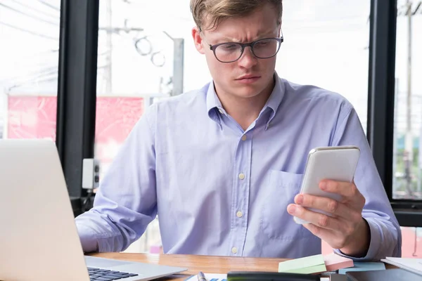 Hombre de negocios enojado utilizar el teléfono móvil en el lugar de trabajo. hombre mensajes de texto mes — Foto de Stock