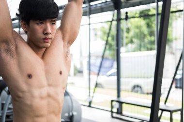 genç adam ile makine fitness merkezinde egzersiz yürütmek. Erkek 