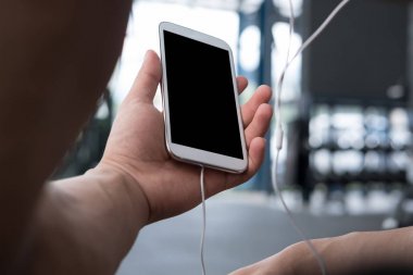 genç adam fitness merkezinde cep telefonu kullanın. erkek atlet liste