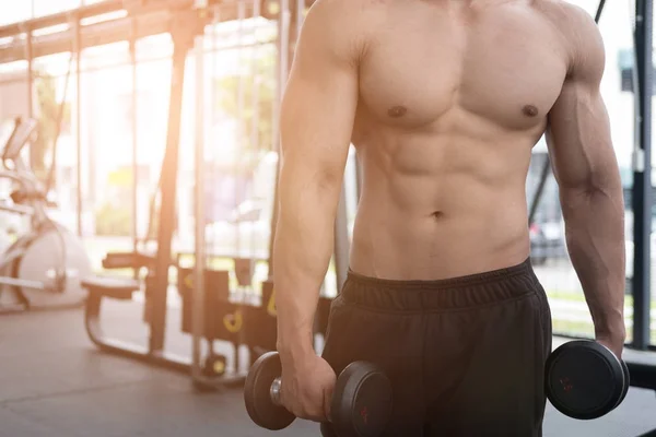 Hombre levantar mancuerna en el gimnasio. culturista masculino haciendo ejercicio en fitnes —  Fotos de Stock