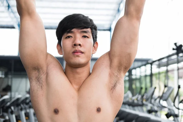 Joven ejecutar el ejercicio con la máquina en el gimnasio. macho — Foto de Stock