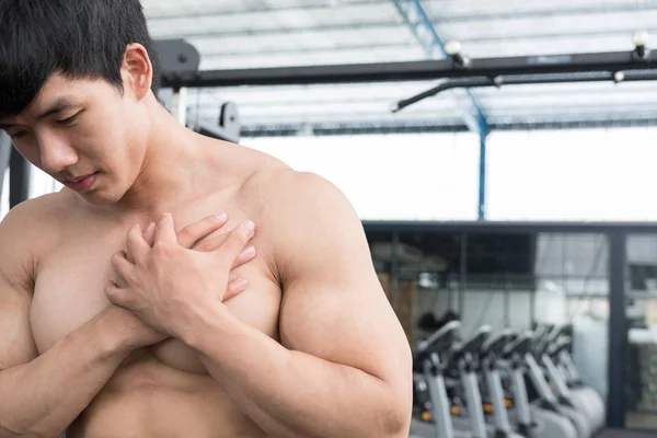 Muskularny mężczyzna o bólu na ramieniu w siłowni. młody człowiek zranić — Zdjęcie stockowe