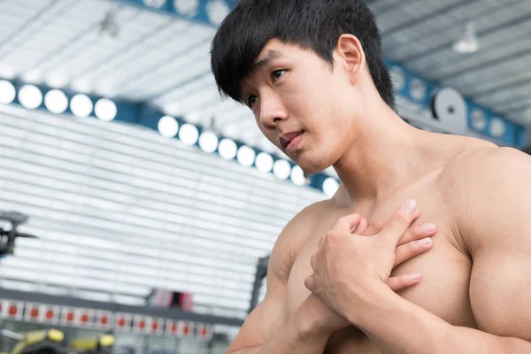 Masculino musculoso com dor no ombro no ginásio. jovem machucar — Fotografia de Stock