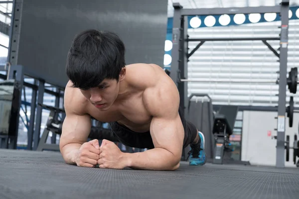 Hombre musculoso haciendo posición de tablón en el gimnasio. culturista masculino trabajo —  Fotos de Stock