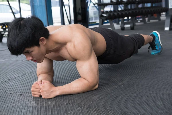 Hombre musculoso haciendo posición de tablón en el gimnasio. culturista masculino trabajo —  Fotos de Stock