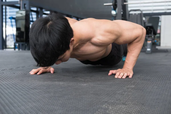 Hombre muscular haciendo flexiones en el gimnasio. culturista masculino haciendo ejercicio i —  Fotos de Stock