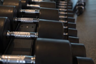 Halter salonunda satır. Siyah dumbbell spor fitness cen içinde ayarla