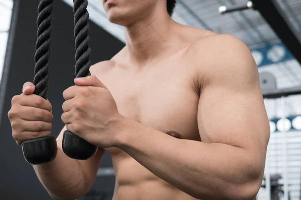 Jonge man in fitness oefening uitvoeren met Gewichtheffen machine — Stockfoto
