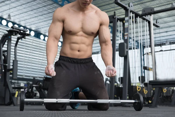 Hombre muscular ejecutar ejercicio en el gimnasio. atleta masculino pu — Foto de Stock