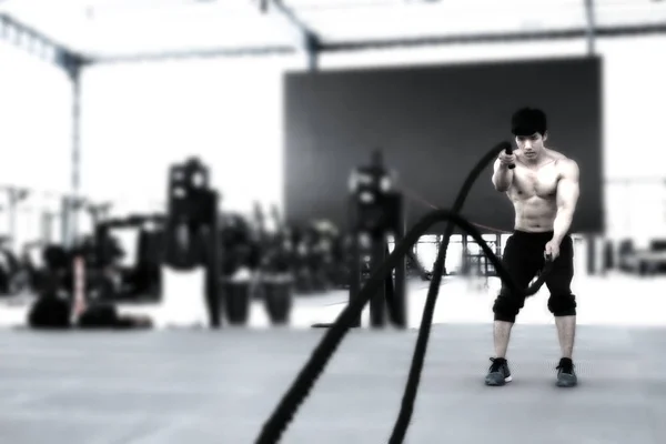 Junger Mann führt Übung im Fitnesscenter durch. männliche Athleten trainieren — Stockfoto