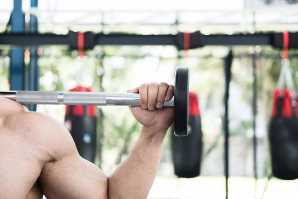 Hombre muscular ejecutar ejercicio en el gimnasio. atleta masculino pu —  Fotos de Stock