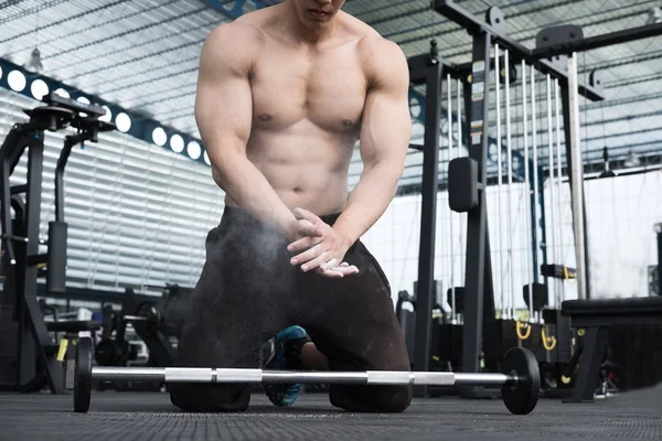 Homem muscular palmas mão no centro de fitness. atleta masculino bomba até m — Fotografia de Stock