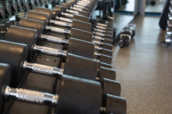 Halter salonunda satır. Siyah dumbbell spor fitness cen içinde ayarla