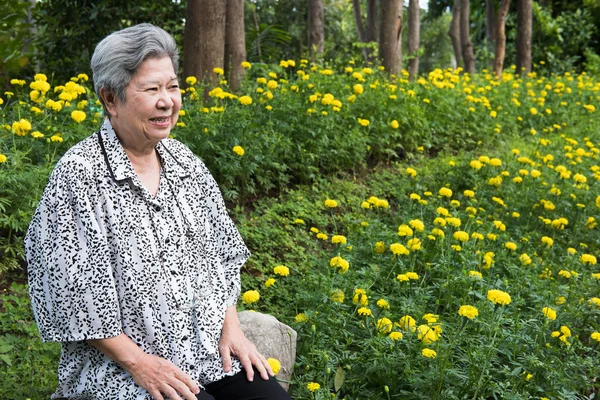 在花园里休息的老妇人。公园里的老年女性放松. — 图库照片