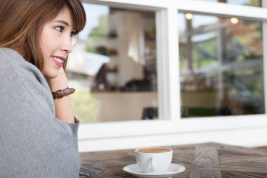 kadın oturup Cafe ahşap masa Durin'in sıcak cappuccino kahve ile