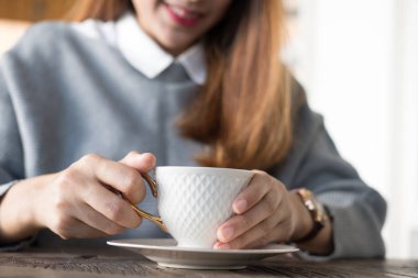 kadın oturup Cafe ahşap masa Durin'in sıcak cappuccino kahve ile