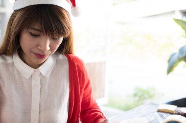 kadın santa şapka giymek. Asyalı kadın giyim beyaz gömlek ve kırmızı örgü