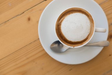ahşap masa üzerinde beyaz fincan sıcak cappuccino kahve