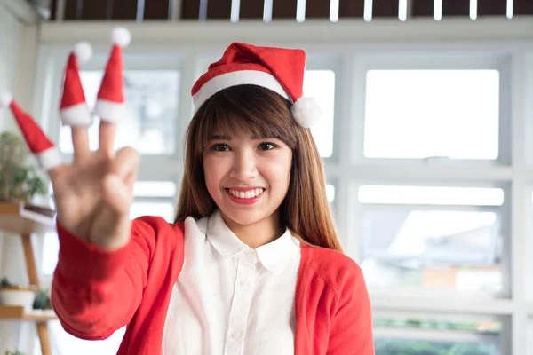 女人戴圣诞老人帽子显示三手指。亚洲女性穿白衣 — 图库照片
