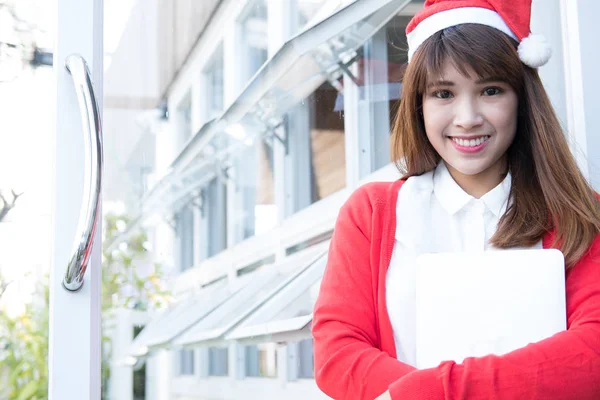 Mulher usar chapéu de Papai Noel segurando laptop em sua loja. asiático feminino nós — Fotografia de Stock