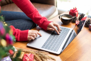 Evde dizüstü bilgisayarda yazan bir kadın. Kız Xmas sırasında bilgisayar kullanıyor. chr