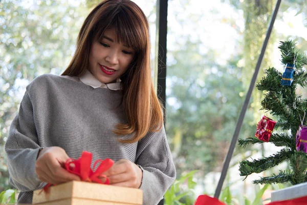 Femme décorer boîte cadeau de Noël avec ruban. salutations de saison pour w — Photo