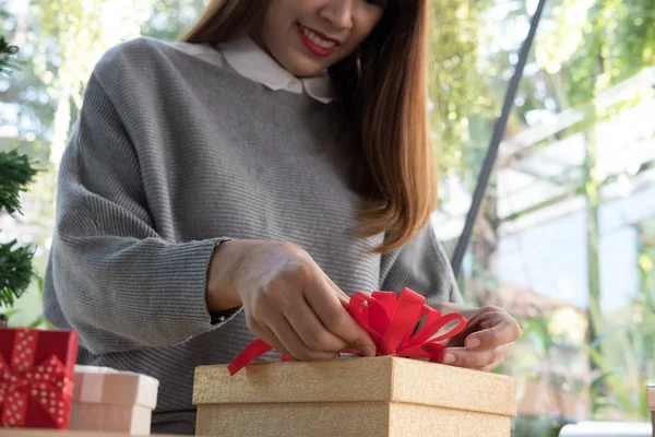 Femme décorer boîte cadeau de Noël avec ruban. salutations de saison pour w — Photo