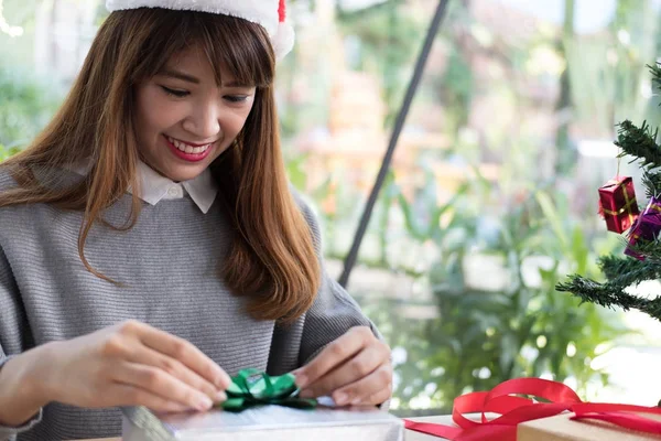 Femme décorer boîte cadeau de Noël avec ruban. salutations de saison pour w — Photo