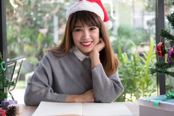 亚洲女人在家戴圣诞老人帽子。女孩与笔记本, gi — 图库照片