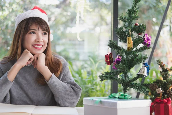 Donna asiatica indossare cappello Babbo Natale a casa. ragazza con taccuino, gi — Foto Stock