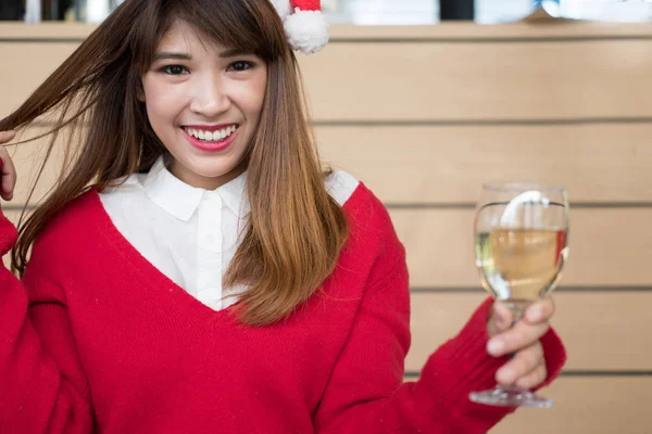 Γυναίκα που φοράει καπέλο santa claus & κόκκινο πουλόβερ που κρατά ποτήρι κρασί f — Φωτογραφία Αρχείου