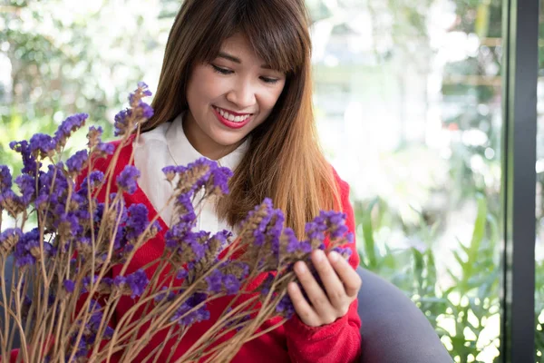 捧着紫花的花束的女人微笑. — 图库照片