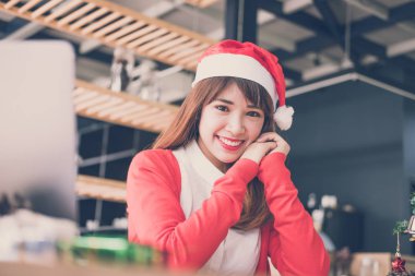 Asyalı kadın evde santa claus şapka giymek. Noel kızla tr