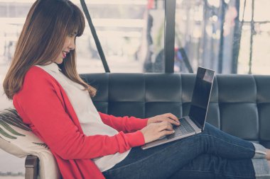 kadın evde kanepede otururken bilgisayarda yazarak başlatmak.