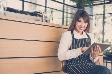 kahve dükkanında kasaya tablet tutan küçük işletme sahibi. f