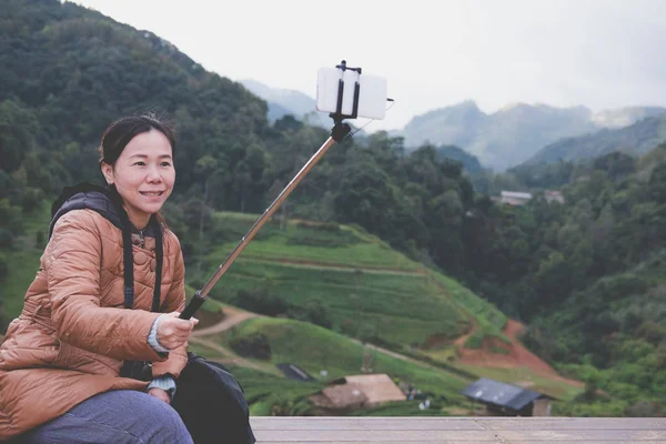 Toeristische gebruik slimme telefoon om selfie foto met berg vie — Stockfoto