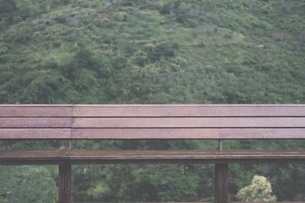 Sedia in legno con vista sulle montagne al mattino. collina nel giorno di pioggia . — Foto Stock