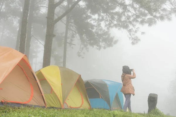 Turista tomar fotos cerca de la tienda en la niebla y la niebla. camping en el bosque. p —  Fotos de Stock