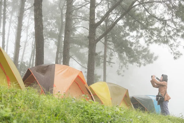 Турист фотографируется рядом с палаткой в тумане и тумане. кемпинг в лесу. p — стоковое фото